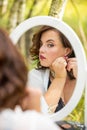 A beauty woman sitting and looking in the mirror in the forest, morning of the bride, natural beauty Royalty Free Stock Photo