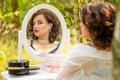 A beauty woman sitting and looking in the mirror in the forest, morning of the bride, natural beauty Royalty Free Stock Photo