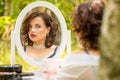 A beauty woman sitting and looking in the mirror in the forest, morning of the bride, natural beauty Royalty Free Stock Photo