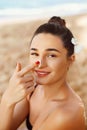 Beauty Woman smile applying sun cream on face. Skin care. Body Sun protection. sunscreen. Female smear moisturizing lotion on sk