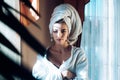 Beauty woman with towel on head relaxing, after spa or morning shower. Woman in bathrobe after wellness and skin care Royalty Free Stock Photo