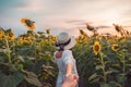 Beauty woman in white dress holding hands a couple in sunflower field at evening