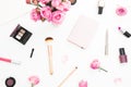 Beauty workspace with pink roses bouquet, cosmetics, diary on white background. Top view. Flat lay home feminine desk. Fashion blo