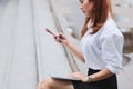 Beauty young Asian business woman using laptop and mobile smart phone for job at outside office. Royalty Free Stock Photo
