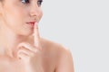 Beauty young asian woman gesture finger on mouth showing hush quiet and secret about skin care on face isolated