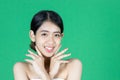 Beauty young Asian woman touching her face over green isolated background. Healthy skin care concept Royalty Free Stock Photo