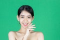 Beauty young Asian woman touching her face over green isolated background. Healthy skin care concept Royalty Free Stock Photo