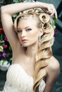 Beauty young bride alone in luxury vintage interior with a lot of flowers, makeup and creative hairstyle