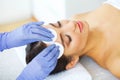 Beauty. Young Girl in Beauty Salon. Cosmetologist Cleans the Skin of the Face with Cotton Pads. Lying on the Massage