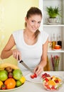 Beauty, young girl making fruit-salad Royalty Free Stock Photo