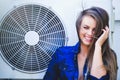 Beauty young woman with air conditioning. near the fan happy laughing. Long hair. Fashionable lady with a beautiful hairdo, makeup Royalty Free Stock Photo