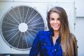 Beauty young woman with air conditioning. near the happy fan. Long hair. Fashionable lady with a beautiful hairdo, makeup. against