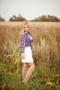 Beauty young woman in checkered shirt and white dress outdoors enjoying nature. Cowgirl style. Royalty Free Stock Photo