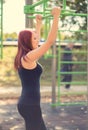 Beauty young woman chin ups in park