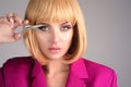 Beauty young woman cutting hair with scissors isolated on studio background. Beautiful girl about to cut hair. Hair cut Royalty Free Stock Photo