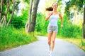 Beauty young woman with earphones running in the park Royalty Free Stock Photo
