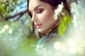 Beauty young woman enjoying nature in spring apple orchard, Happy beautiful girl in a garden with blooming fruit trees