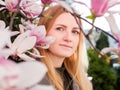 Beauty young woman enjoying nature in spring magnolia garden. Romantic fashion model in blossom flowers portrait Royalty Free Stock Photo