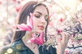 Beauty young woman enjoying nature in spring spring magnolia flowers. Beautiful brunette girl in Garden with blooming magnolias Royalty Free Stock Photo