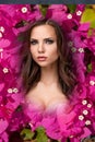 The beauty young woman with flowers of pink bougainvillea