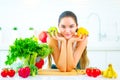Beauty young woman holding fresh vegetables and fruits in her kitchen at home