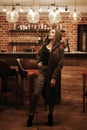 Beauty young woman in hooded coat portrait at a night bar alone