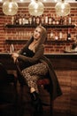 Beauty young woman in hooded coat portrait at a night bar alone