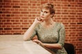 Beauty young woman portrait waiting someone at a bar. Plus size girl in a glitter party dress alone in the cafe. Royalty Free Stock Photo