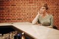 Beauty young woman portrait waiting someone at a bar. Plus size girl in a glitter party dress alone in the cafe. Royalty Free Stock Photo