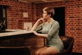 Beauty young woman portrait waiting someone at a bar. Plus size girl in a glitter party dress alone in the cafe. Royalty Free Stock Photo