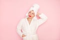 Beauty Young woman with red lips standing in the bath robe on the pink background Royalty Free Stock Photo