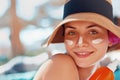 Beauty Young woman with sun cream on face holding sunscreen bottle on the beach. Royalty Free Stock Photo