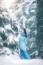 Beauty young woman walking outdoors in winter park under the fir tree covered snow. Beautiful model girl posing Royalty Free Stock Photo