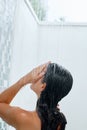 Beauty Young woman washing hair in bathroom. Beautiful model brunette girl taking shower. Royalty Free Stock Photo