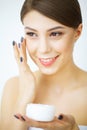 Beauty Youth Skin Care Concept - Close up Beautiful Caucasian Woman Face Portrait applying some cream to her face for skin care. Royalty Free Stock Photo