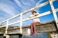 Beautyful asian woman resting is looks at the sea bay with houses and boats on a sunny day at Childrens bay, Akaroa, Canterbury, Royalty Free Stock Photo