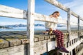 Beautyful asian woman resting is looks at the sea bay with houses and boats on a sunny day at Childrens bay, Akaroa, Canterbury, Royalty Free Stock Photo