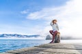 Beautyful asian woman resting is looks at the sea bay with houses and boats on a sunny day at Childrens bay, Akaroa, Canterbury, Royalty Free Stock Photo