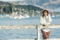 Beautyful asian woman resting is looks at the sea bay with houses and boats on a sunny day at Childrens bay, Akaroa, Canterbury, Royalty Free Stock Photo