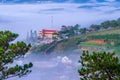 Da lat, lam dong, viet nam- feb 12, 2017: beautyful landscape of da lat city, a small vietnamese pagoda in fog and the pine hill Royalty Free Stock Photo