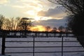 A beautyful sunset with cloudy sky a cattle gate in the foreground