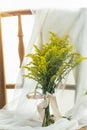 Beautyful yellow flower bouquet with white linen cloth on wooden chair Royalty Free Stock Photo