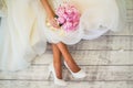 The bride in a white dress and shoes with a bouquet in her hands Royalty Free Stock Photo