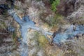 Beaver dam on forest river at early spring time, drone view. Stream, treetops, wetland. Aerial landscape