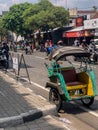 Becak is a traditional three-wheeled mode of transportation driven by a human