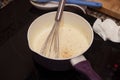 Bechamel sauce in a pan with condiments and whisk. Royalty Free Stock Photo