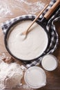 Bechamel sauce in a pan and flour, milk on the table top view