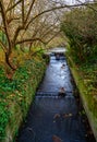 The Beck river with small waterfalls in Beckenham, UK Royalty Free Stock Photo