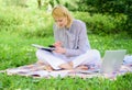 Become successful freelancer. Woman with laptop sit on rug grass meadow. Girl with notepad write note. Freelance career