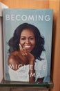 Becoming book written by Michelle Obama at the bookstore. books by Michelle Obama displayed on the shelves of a book shop. Library